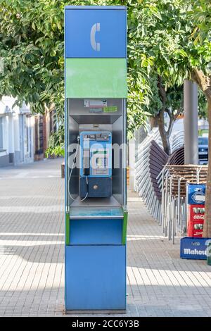 Huelva, Spain - August 16, 2020: Phone booth from Telefonica company in the town center pf Valverde del Camino. One of old and useless public phones t Stock Photo
