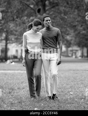 1960s 1970s ROMANTIC AFRICAN-AMERICAN COUPLE ARM IN ARM IN PARK - r22877 HAR001 HARS STRONG PLEASED JOY LIFESTYLE SATISFACTION FEMALES MARRIED SPOUSE HUSBANDS HOME LIFE COPY SPACE FRIENDSHIP FULL-LENGTH LADIES PERSONS CARING MALES CONFIDENCE B&W PARTNER DATING HAPPINESS CHEERFUL LEISURE AFRICAN-AMERICANS AFRICAN-AMERICAN BLACK ETHNICITY ATTRACTION RELATIONSHIPS SMILES CONNECTION COURTSHIP JOYFUL STYLISH PERSONAL ATTACHMENT POSSIBILITY AFFECTION COOPERATION EMOTION SOCIAL ACTIVITY TOGETHERNESS WIVES YOUNG ADULT MAN YOUNG ADULT WOMAN BLACK AND WHITE CASUAL COURTING HAR001 OLD FASHIONED Stock Photo