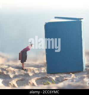 surreal moment of a small woman who dreams of snooping in the pages of giant books Stock Photo
