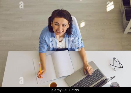 Top view of young woman taking online educational class or participating in web conference from home Stock Photo