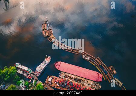 Abstract art industrial background with copy space. Abandoned pier and boats with reflection of sky in the water. Aerial close up drone view. Stock Photo