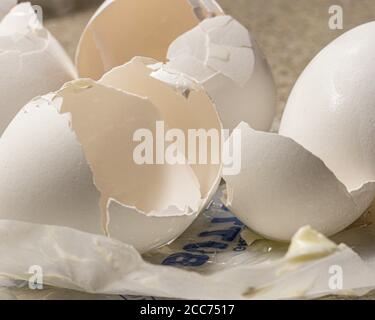 egg shells from baking eggs on empty butter wrapper Stock Photo