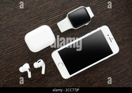 Izmir, Turkey - August 7, 2020: Close up shot of white colored Iphone 8, Apple Watch 5, and Air Pods pro on a wooden ground. Stock Photo