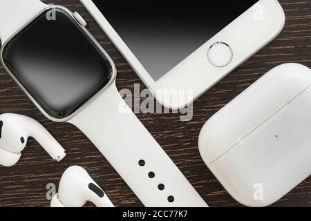 Izmir, Turkey - August 7, 2020: Close up shot of white colored Iphone 8, Apple Watch 5, and Air Pods pro on a wooden ground. Stock Photo