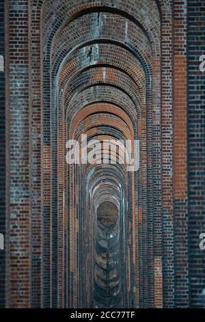 View through the arches of the Ouse Valley Viaduct (Balcombe Viaduct) carrying the London to Brighton Railway Line over the River Ouse in Sussex, UK Stock Photo