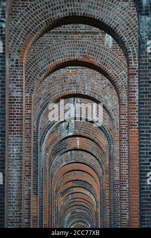 View through the arches of the Ouse Valley Viaduct (Balcombe Viaduct) carrying the London to Brighton Railway Line over the River Ouse in Sussex, UK Stock Photo