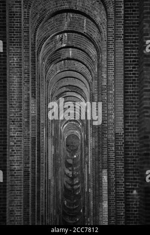 View through the arches of the Ouse Valley Viaduct (Balcombe Viaduct) carrying the London to Brighton Railway Line over the River Ouse in Sussex, UK Stock Photo