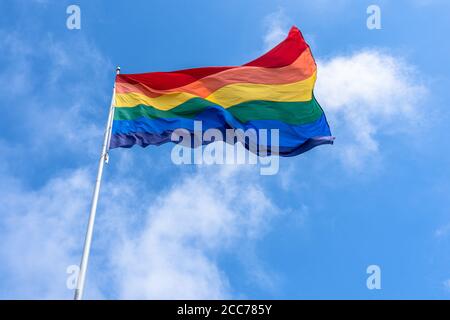 Large rainbow flag, symbol of gay pride, flying high in San Francisco, California Stock Photo