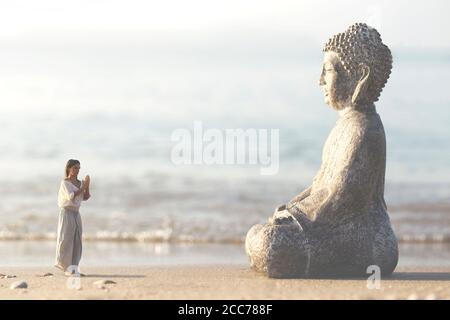 woman prays meditating in front of the Buddha statue Stock Photo