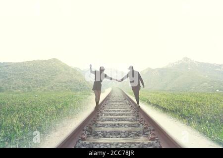 young couple walks on rails to an unknown destination Stock Photo
