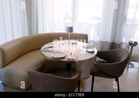 casual dining table set up with sofas, chair and cutlery sets Stock Photo
