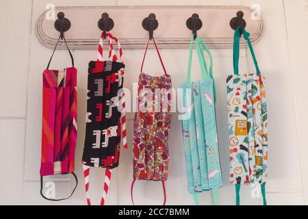 Group of Five Patterned Cute Masks hanging on hooks Stock Photo