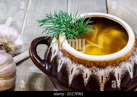 Vegetable soup in a pot with bread and fresh garlic on a gray wooden background Stock Photo