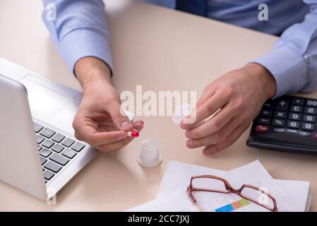 Sick male employee suffering at the workplace Stock Photo