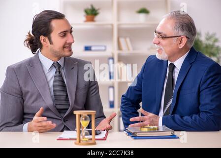Two businessmen in the time management concept Stock Photo