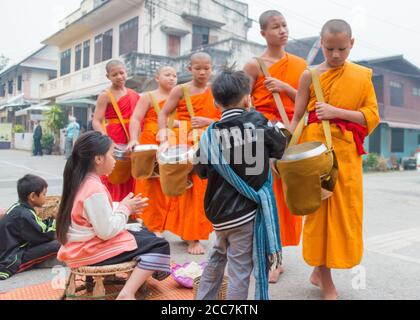 Luang Prabang, Laos - Lao buddhist monks alms giving ceremony on the morning. Luang Prabang is part of UNESCO World Heritage Site. Stock Photo