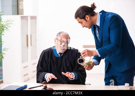 Police inspector arresting judge in court Stock Photo