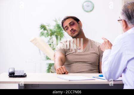 Young face injured man visiting experienced male doctor traumatologist Stock Photo