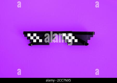 Funny pixelated boss sunglasses on purple background. Gangster, Black thug life meme glasses . Pixel 8bit style Stock Photo