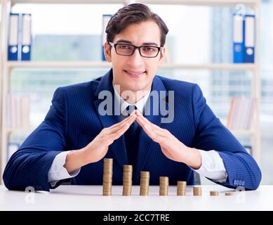 The businessman with stacks of coins in the office Stock Photo