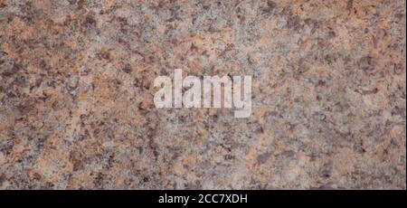 Dark brown granite with light inclusions, the texture of a natural polished stone close-up. Horizontal positioning. Stock Photo