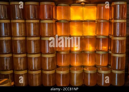 Tower and rows of Golden yellow honey in glass jar on wooden board Closeup Copy space. Stock Photo