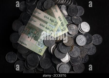 Stack of Indian coins and five rupees note on a black background Stock Photo