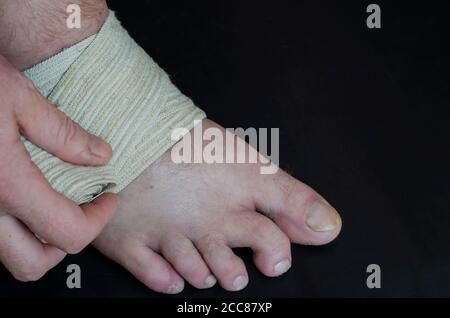 Middle-aged Caucasian man produces an independent bandage of