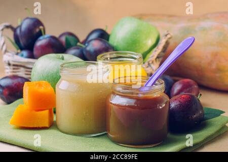 Jars with baby food plum, pumpkin and apple puree Stock Photo
