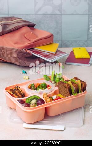 https://l450v.alamy.com/450v/2cc89yc/lunch-box-on-the-table-near-school-or-student-backpack-2cc89yc.jpg