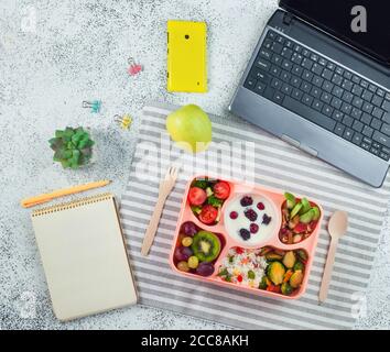 Open lunch box with healthy lunch with empty notebook on grey background Stock Photo