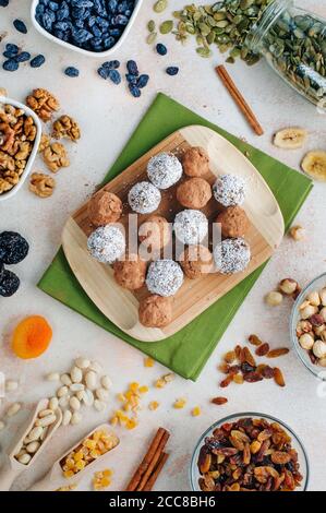 Vegan candies from dried fruits covered with cocoa powder and coconut chips Stock Photo