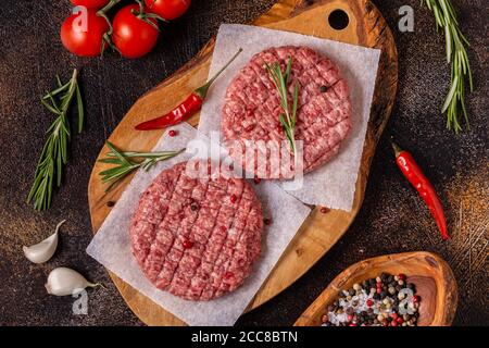 Fresh raw minced homemade grill beef burgers on wooden chopping board, top view Stock Photo