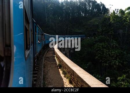 View from the window of a blue train in Sri Lanka. On the nine arches Bridge, Viaduct. Journey between Ella and Kandy Stock Photo