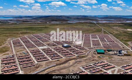 (200820) -- GOLOG, Aug. 20, 2020 (Xinhua) -- Aerial photo taken on Aug. 19, 2020 shows a view of Ghadan Village of Machali Township, Madoi County, Golog Tibetan Autonomous Prefecture, northwest China's Qinghai Province. As of October 2018, a total of 1,036 registered poverty-stricken residents have moved from Madoi County's less hospitable lands to Ghadan, a relocation village newly built within the Yellow River source area. The new village has better transportation which makes it easier for villagers to find jobs or start businesses in other towns. Meanwhile, many villagers get paid as envi Stock Photo