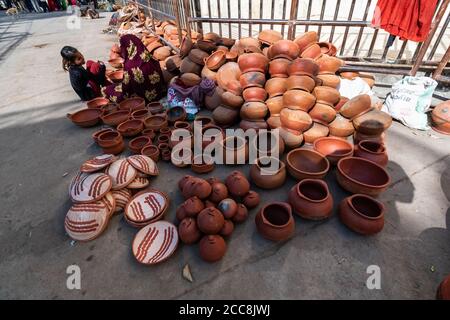 Orchha, Madhya Pradesh, India - March 2019: Two Indian women sitting on the street beside their shop selling clay earthenware pots and utensils. Stock Photo