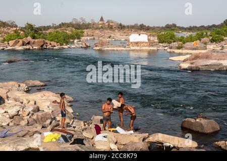 Orchha, Madhya Pradesh, India - March 2019: People bathing on the rocky banks of the Betwa river in the village of Orchha. Stock Photo