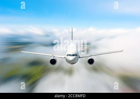 Passenger Airliner flying in the clouds high speed Stock Photo