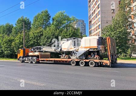 Transportation of equipment for cutting and removing old asphalt pavement for road repair truck platform of a truck trailer on highway in a city Stock Photo