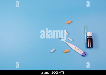Medication for sore throat, flu, runny nose on blue background Stock Photo