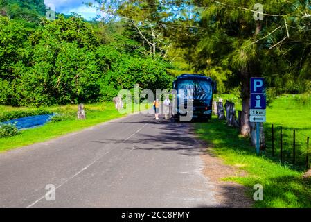 Moorea, French Polynesia: 09/03/2018: Street view of one of the main street in Moorea, there is just one way with tropical trees around Stock Photo