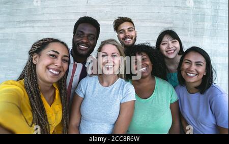 Group multiracial friends having fun outdoor - Happy mixed race people taking selfie together Stock Photo