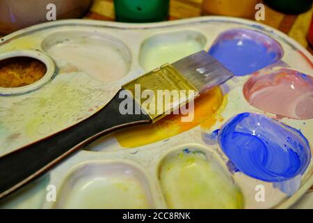 Paintbrush artist palette and multi colored gouache. Stock Photo