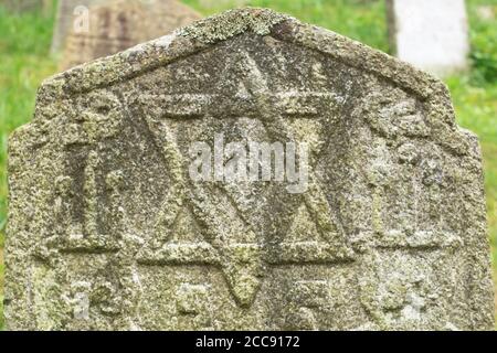 Old Jewish gravestone in the old Jewish cemetery. Star of David on an ancient stone tombstone. Stock Photo