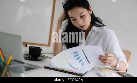 Serious focused businesswoman working with financial marketing report Stock Photo