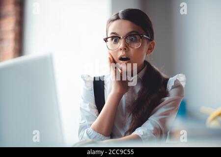 Cute brunette girl in eyeglasses feeling schocked Stock Photo