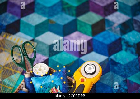 Quilting accessories on the background of a tumbling blocks quilt Stock Photo