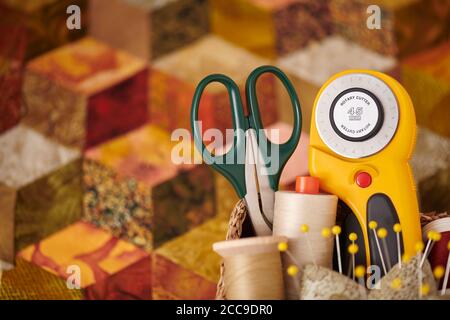 Quilting accessories on the background of a tumbling blocks quilt Stock Photo
