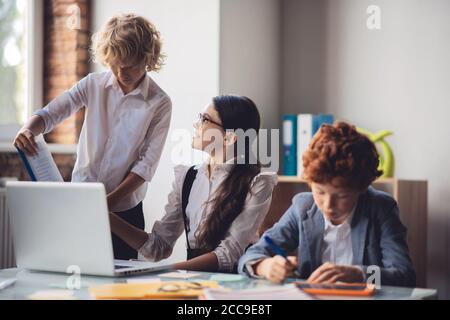 Three classmates working on a project together Stock Photo