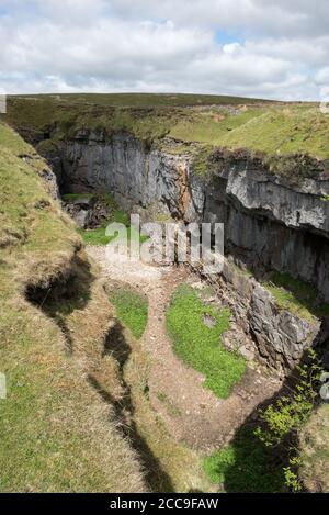 Hull Pot, an impressive collapsed cavern on the slopes of Pen-y-Ghent in the Yorkshire Dales National Park Stock Photo